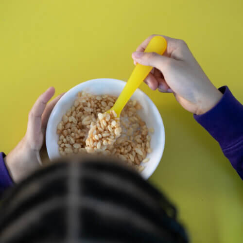 Image of a child eating a bowl or rice cripies.